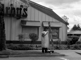 Guy dressed up like a mattress standing outside Ar.jpg